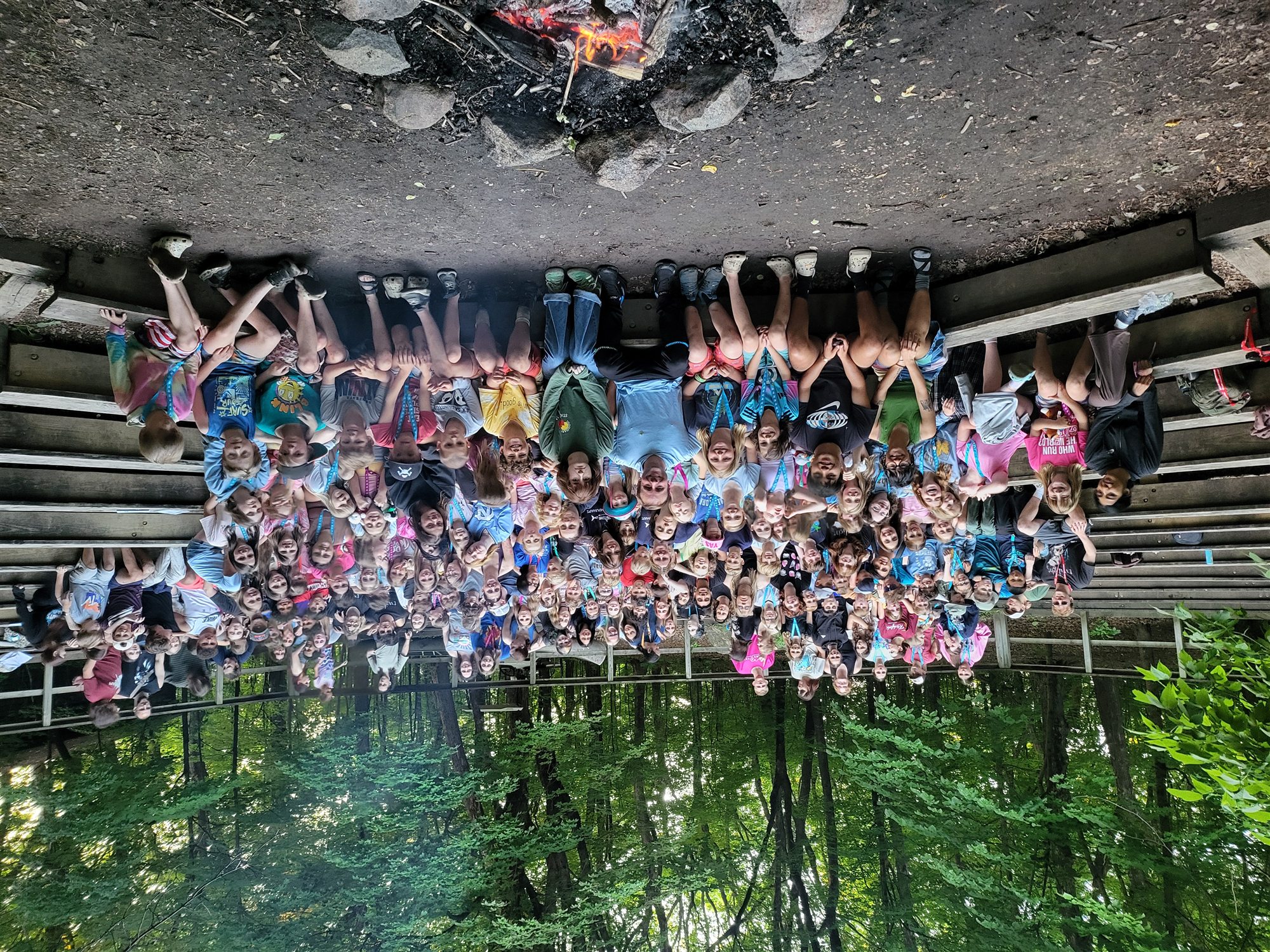 A large group gathered around a campfire at Camp Ihduhapi